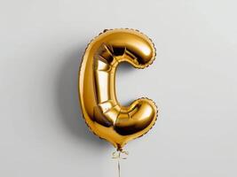 Golden Foil Balloon Letter C on White Background for Celebratory Events photo