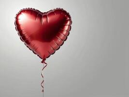 A red heart-shaped foil balloon with a shiny surface, floating against a gray background. photo