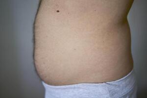 the side and stomach of a thirty-year-old man of average build photo