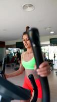 A woman is working out on an elliptical trainer, showing commitment to fitness and health video