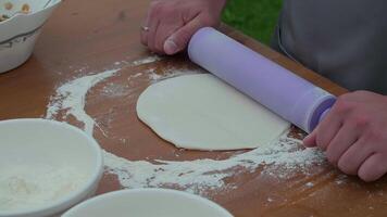 rolling the dough with a rolling pin, the cook prepares the dough for baking video