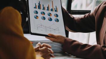 Financial analysts analyze business financial reports on a digital tablet planning investment project during a discussion at a meeting of corporate showing the results of their successful teamwork. video