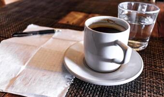 Cup of coffee with notepad and ballpoint pen on table Mexico. photo