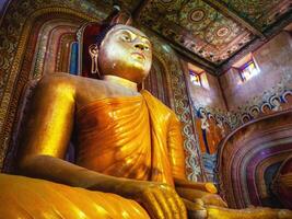 giant golden sitting buddha in Sri Lanka temple bottom view close up. Wewurukannala Buduraja Maha Viharaya temple photo