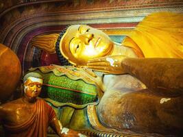 giant golden lying buddha in Sri Lanka temple bottom view close up. Wewurukannala Buduraja Maha Viharaya temple. photo