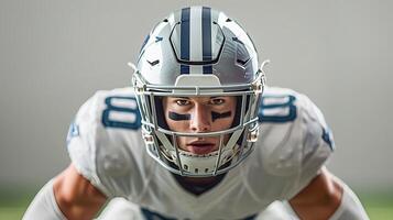 American football player in a gray helmet and white uniform stands waiting for the ball to be drawn photo
