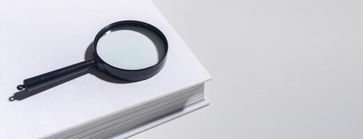 Office document magnification, magnifying glass on paper. Business concept with lens and book photo