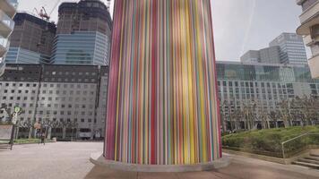 Paris, France - March 20, 2024 - The Moretti, also known as La Cheminee, is an iconic art installation in La Defense a colorful, cylindrical structure multicolored tubes video