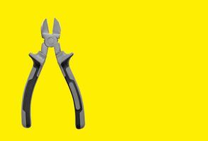 Industrial pliers, diagonal cutting tool for wire and cable. Yellow background with copy space, photo