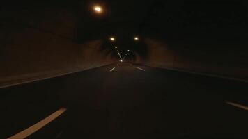 First person view as car drives through tunnel in mountains.mountain tunnel showcases engineering within natural landscapes. The emphasizes the experience of driving through a mountain tunnel video