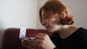 Caucasian Woman Applying Eyeshadow On Her Face video