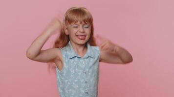 Overjoyed happy child girl kid showing rock n roll gesture, cool sign dancing rejoicing in success video