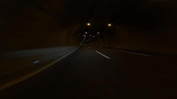 First person view as car drives through dark tunnel in mountains. dark drive highlights tunnels engineering and structure. Experience dark drive in mountain tunnel focusing on construction of tunnel video