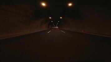 First person view as car drives through tunnel in mountains underground highway stretches ahead, showcasing engineering. Experience underground highways structure as light fades and journey continues video