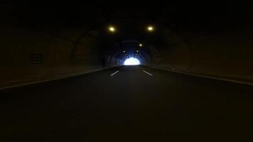 First person view, car leaves tunnel in mountains. The tunnel exit reveals mountain landscape, contrasting artificial light with natural light video