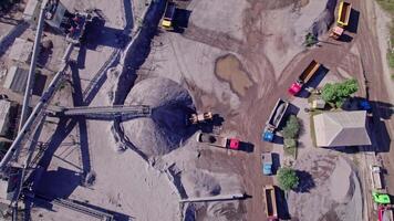Excavator loading crushed stone into a dump truck in a crushed stone quarry video