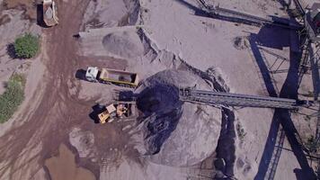 Excavator loading crushed stone into a dump truck in a crushed stone quarry video
