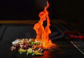 chef's hands with spatula over teppanyaki. Teppan show photo