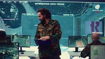 Officer analyzes intelligence reports to anticipate enemy movements and adjust strategies accordingly. Monitoring real time battlefield data to provide critical updates to commanders. Camera B. video