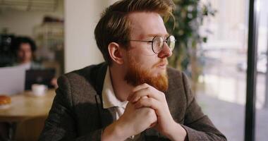 Portrait Of Unhappy Businessman Sitting In Front Of Open Laptop In Cafe, Looking At Display video