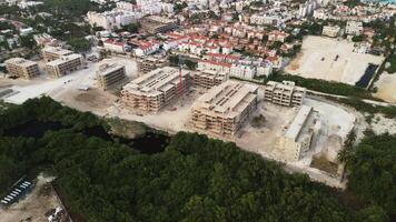 Aerial view of building a hotel along the Caribbean coastline in the Dominican Republic with the sunset in the background. construction crane video