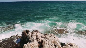 Enchanting Serenity. A Glimpse of the Majestic Ocean From a Rocky Shore Experience the raw beauty of crashing turquoise waves against rocky shores in this mesmerizing ocean view. video