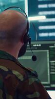 Vertical Male IT specialist operating on reconnaissance system to transmit real time data for new field mission, working in military command center. Telecommunications operator provides air support. Camera A. video