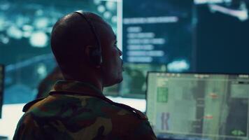 Army personnel applying national safety protocols by verifying all ships anchoring in the coastal ports, using radar surveillance on big screen in military command post. Federal operations. Camera A. video