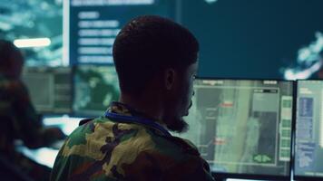 Army officer develops contingency plans to address unexpected developments in the field, studying real time satellite intelligence in military command post. Soldier tracking enemy servers. Camera A. video