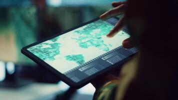 Navy operations specialist examines a world map with gps system on his tablet, working on finding tracks of enemy vessels. General employs government satellite data for missions. Close up. Camera A. video