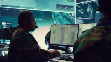 Female army operator registers important information from military surveillance system, working in control room base of operations to gather intelligence for the troops. National safety. Camera B. video