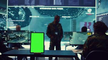 Isolated greenscreen display running on a tablet in military power base, soldiers follow surveillance footage to stay alert in case of a hostile attack. Satellite system for reconnaissance. Camera B. video