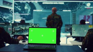 Greenscreen running on a laptop in military base command center, team of army officers monitoring coast line activity to ensure national safety. Soldiers detecting suspicious vessels. Camera B. video