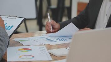 Financial analysts analyze business financial reports on a digital tablet planning investment project during a discussion at a meeting of corporate showing the results of their successful teamwork. video
