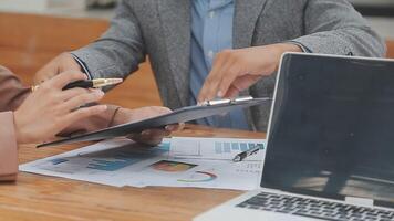 Financial analysts analyze business financial reports on a digital tablet planning investment project during a discussion at a meeting of corporate showing the results of their successful teamwork. video