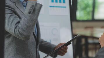 Financial analysts analyze business financial reports on a digital tablet planning investment project during a discussion at a meeting of corporate showing the results of their successful teamwork. video