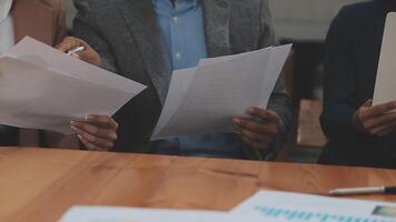 Financial analysts analyze business financial reports on a digital tablet planning investment project during a discussion at a meeting of corporate showing the results of their successful teamwork. video