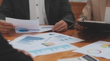 Financial analysts analyze business financial reports on a digital tablet planning investment project during a discussion at a meeting of corporate showing the results of their successful teamwork. video