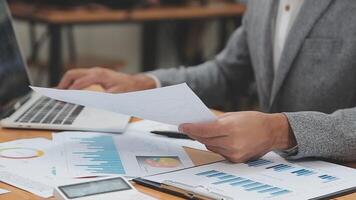 Financial analysts analyze business financial reports on a digital tablet planning investment project during a discussion at a meeting of corporate showing the results of their successful teamwork. video