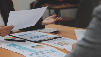 Financial analysts analyze business financial reports on a digital tablet planning investment project during a discussion at a meeting of corporate showing the results of their successful teamwork. video