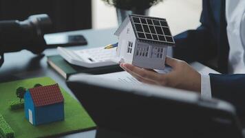 Architecture team and engineer are discussing and brainstorming on floor plan over the clean energy and power saving house design using solar panel for green industry and futuristic home development video