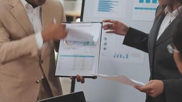 Financial analysts analyze business financial reports on a digital tablet planning investment project during a discussion at a meeting of corporate showing the results of their successful teamwork. video