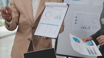 Financial analysts analyze business financial reports on a digital tablet planning investment project during a discussion at a meeting of corporate showing the results of their successful teamwork. video