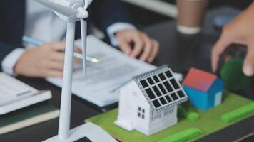 Architecture team and engineer are discussing and brainstorming on floor plan over the clean energy and power saving house design using solar panel for green industry and futuristic home development video