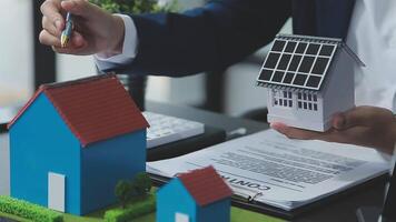 Architecture team and engineer are discussing and brainstorming on floor plan over the clean energy and power saving house design using solar panel for green industry and futuristic home development video