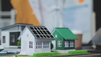 Architecture team and engineer are discussing and brainstorming on floor plan over the clean energy and power saving house design using solar panel for green industry and futuristic home development video