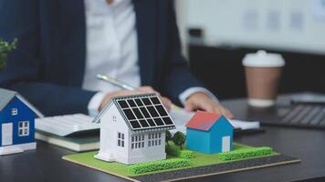 Architecture team and engineer are discussing and brainstorming on floor plan over the clean energy and power saving house design using solar panel for green industry and futuristic home development video