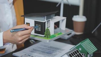 Architecture team and engineer are discussing and brainstorming on floor plan over the clean energy and power saving house design using solar panel for green industry and futuristic home development video