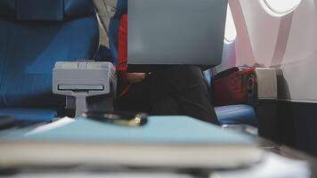 Successful Asian business woman, Business woman working in airplane cabin during flight on laptop computer listening to music with headphones video