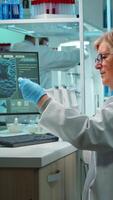 Vertical . Medical research scientist typing codes on pc in biological applied science modern equipped laboratory overwork. Lab engineers conducting experiment for vaccine development against covid19 virus video
